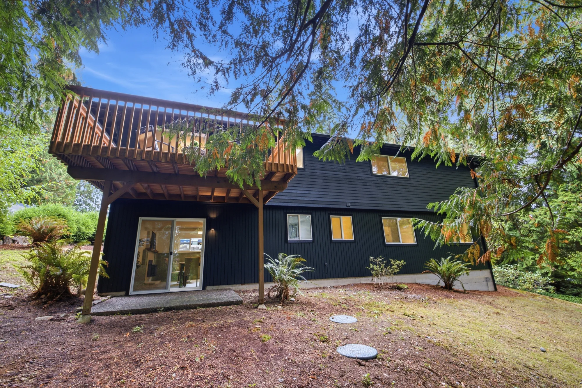 Rear of the home showing deck and lower-level outdoor access